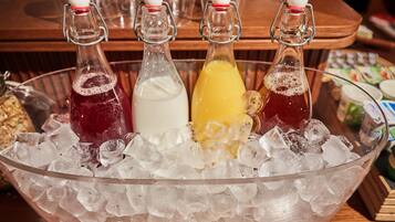 A large glass bowl filled with ice, containing four bottles of beverages.