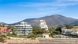 A coastal resort with modern buildings, a swimming pool, and a mountain backdrop. - Sapphire | Sea view - pool - terrace (Estepona)