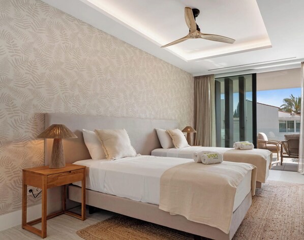 A hotel room with two beds, a ceiling fan, a large window, and a view of the outside. - Sapphire | Sea view - pool - terrace (Estepona)