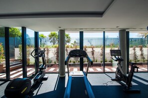 A gym with treadmills, an elliptical, and a stationary bike.