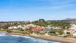 A coastal town with beachfront properties, a hill with a castle-like structure, and a clear sky. - Sapphire | Sea view - pool - terrace (Estepona)