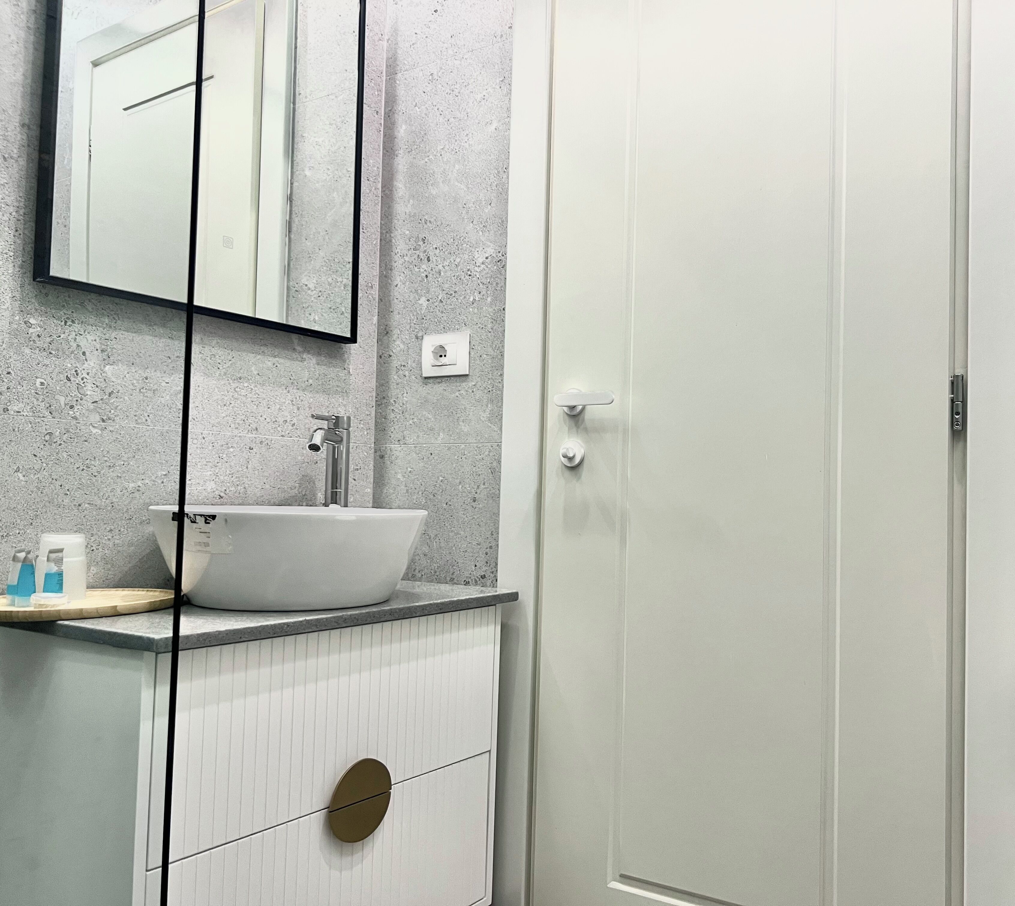A bathroom with a white sink, a mirror, and a toilet.