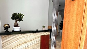 A reception desk with a marble-like design, a potted plant, and a globe. - The MONT BOUTIQUE HOTEL (Shkodër)