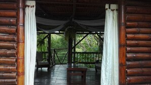 A wooden gazebo with a bench and chairs, surrounded by white curtains, overlooking a lush green forest. - Beautiful 9-bedroom bed & breakfast in adorable Pereira (Pereira)