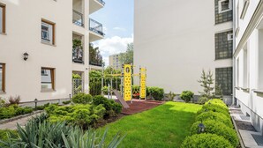 A courtyard with a climbing wall, well-maintained grass, and surrounding buildings.