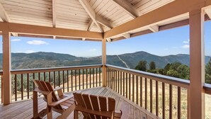 A wooden deck with a table and chairs, overlooking a mountainous landscape. - Cozy Getaway Ranch House and Estate by Yosemite (Jamestown)