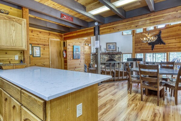 Un interior de madera con cocina, mesa de comedor y chimenea.