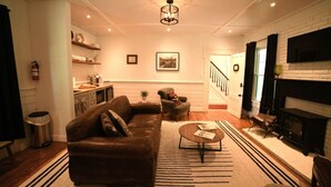Ein Wohnzimmer mit Ledersofa, Couchtisch, Kamin und einer Treppe zu einer weiteren Ebene.