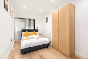 A bedroom with a bed, a wardrobe, and a radiator. - Angel 2 BR, 2 Bath Duplex with Balcony Sleeps 5 (Greater London)