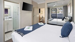 Une chambre d’hôtel avec un lit, une télévision, une salle de bain et un balcon avec vue.