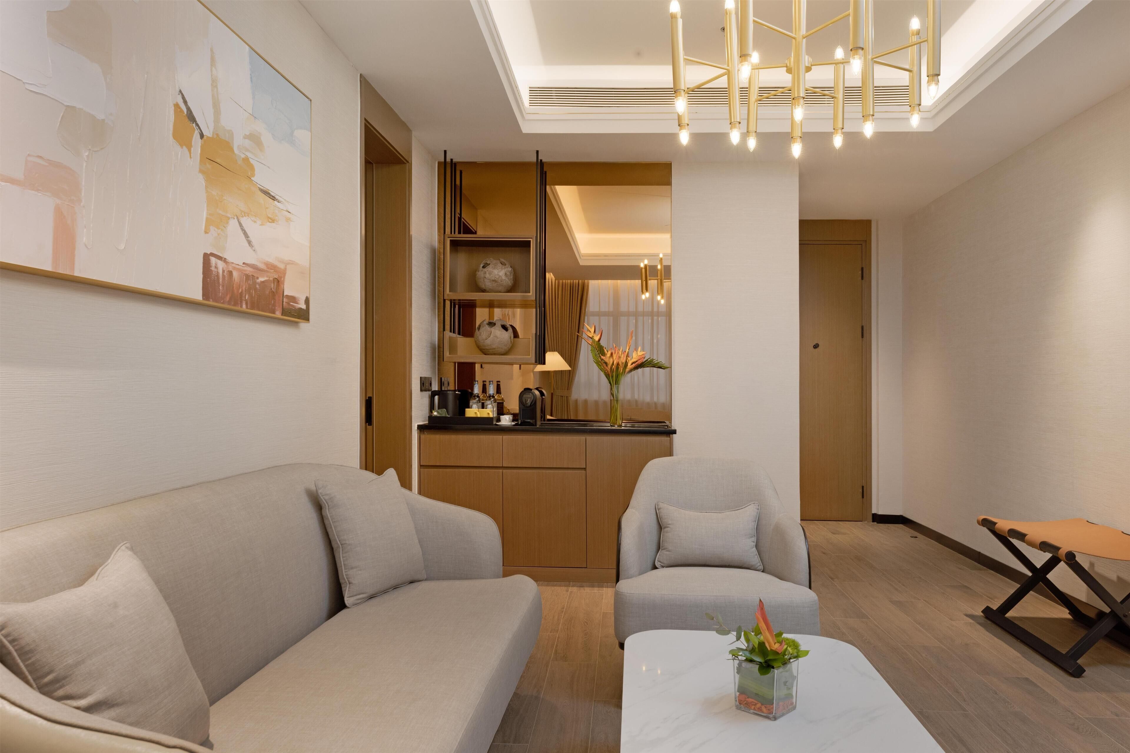 Un salon moderne avec un canapé, une table basse et un coin cuisine à l’arrière-plan.