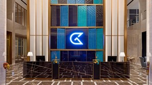 A reception area with a marble floor, a reception desk, and a large illuminated logo on the wall. - Golden Tulip Kin-Oasis Kinshasa (Kinshasa)