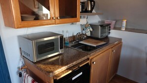 Eine kleine Küche mit Mikrowelle, Toaster und Geschirrspüler.