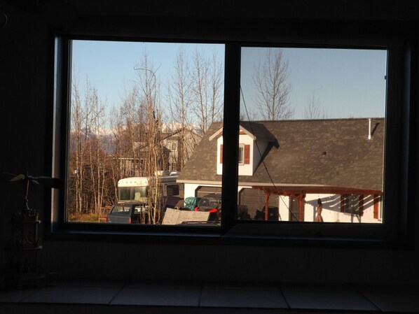 Ein Fenster mit Blick auf ein Wohngebiet, inklusive Häusern und einem Reisemobil.
