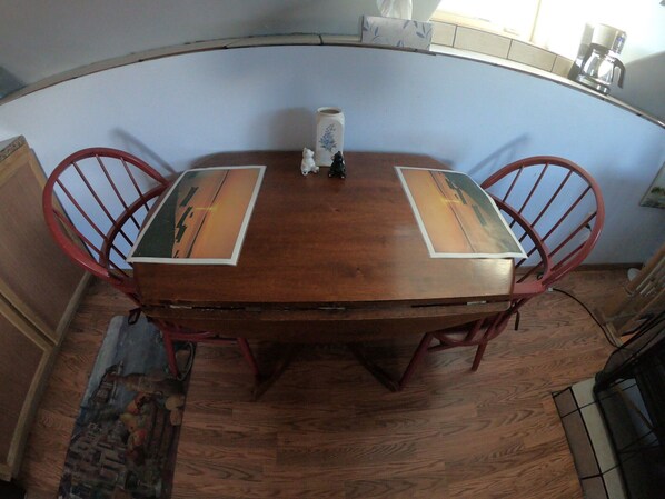 A wooden dining table with two chairs, a vase, and a framed picture on the table. - Windflower B&B: Charming Neighborhood and Stunning Mountain Views (Palmer)