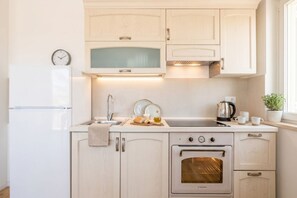 A compact kitchen with a built-in oven, a sink, and a clock on the wall. - Angelina house - Sea Front Loft (Bari)