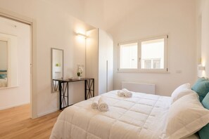 A bedroom with a bed, a bedside table, a mirror, a window, and a radiator. - Angelina house - Sea Front Loft (Bari)