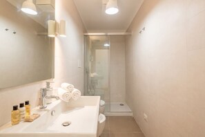 A bathroom with a sink, mirror, and glass shower enclosure. - Angelina house - Sea Front Loft (Bari)