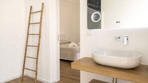 Een badkamer met een houten trap, een grote spiegel en een witte wasbak.