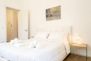 Une chambre d’hôtel avec un lit, une table de chevet avec une lampe et un tableau au mur.