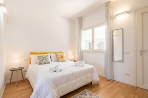 A bedroom with a bed, a bedside table, a window, and a door. - Benjamin House with Private Parking (Bari)