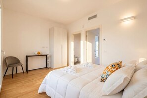A bedroom with a bed, a chair, a small table, and a door leading to a bathroom. - Benjamin House with Private Parking (Bari)