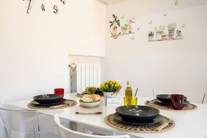 A dining table set with plates, bowls, and cutlery, with a red cup and a bottle on the table.