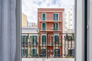 A multi-story building with balconies, a metal railing, and a clear sky. - Casa di Carly - large cozy retreat in center (Bari)