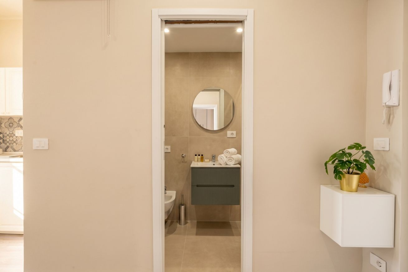 Une salle de bain avec un miroir, un lavabo et un porte-serviettes.