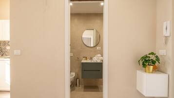 Une salle de bain avec un miroir, un lavabo et un porte-serviettes.