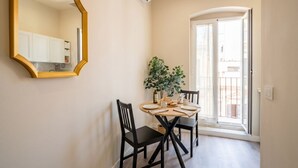 A dining area with a round table, black chairs, a mirror, and a potted plant. - Alba Suite Apartment (Bari)