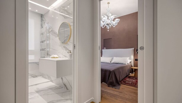 Een moderne slaapkamer met een groot bed, een nachtkastje en een bijzettafeltje.