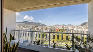 Een balkon met uitzicht op een stadslandschap en bergen.