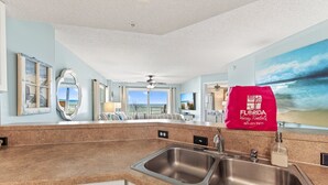 A modern kitchen with a Bosch dishwasher, a large window with a view, and a red Florida Vacay Rentals towel.