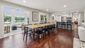 A spacious kitchen with a large island, white cabinets, and a view of a lake.