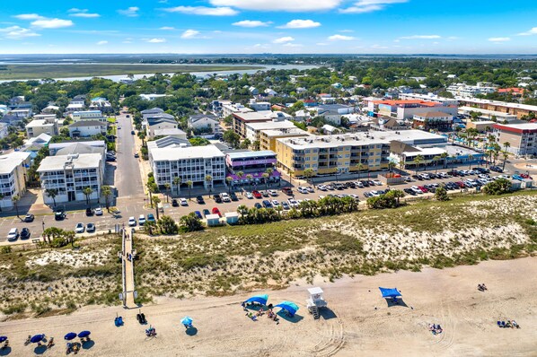 Vue aérienne d’une ville côti ère avec ses bâtiments, sa plage et un parking.