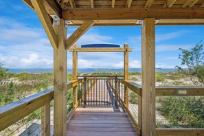 A wooden boardwalk leading to a beach with a clear view of the ocean. - Serene Beach Home w/ private pool & Tesla Charger – Walk to Port Royal Sound! (Hilton Head Island)