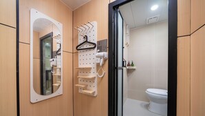 A modern bathroom with a wooden vanity, a mirror, a towel rack, and a toilet. - Windsor Hella Inn (Kowloon)
