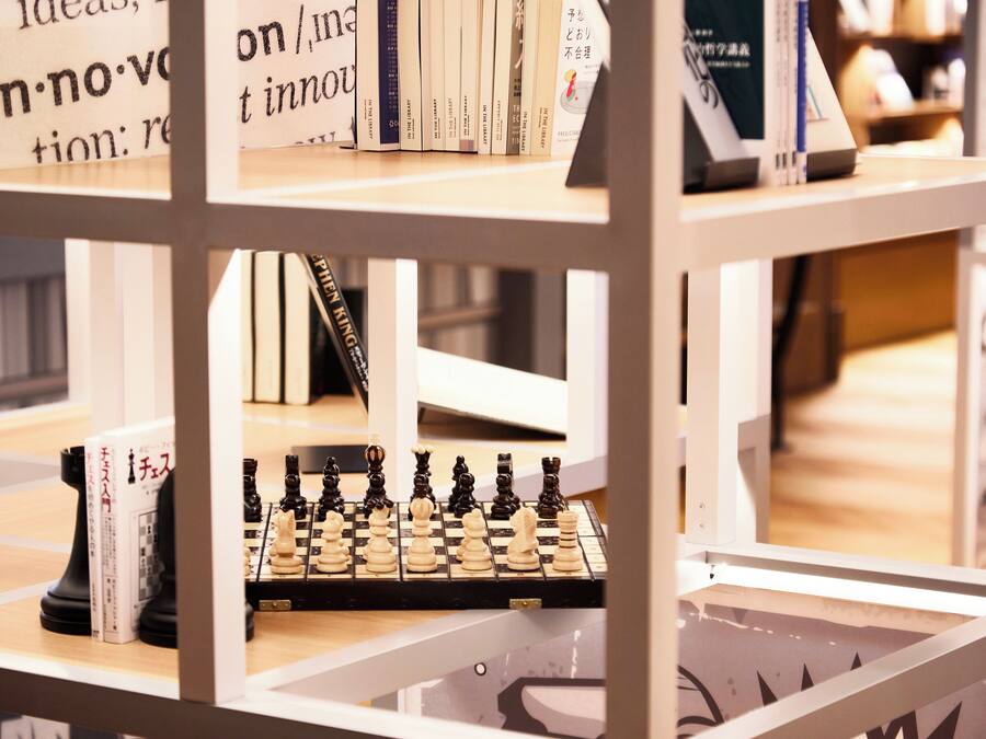 Ein Bücherregal mit Büchern und einem Schachbrett.