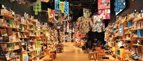 A bookstore with wooden shelves and tables, featuring books and various decorations.