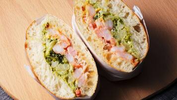 A sandwich cut in half on a wooden board.