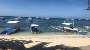 Une plage où plusieurs bateaux sont amarrés près du rivage.