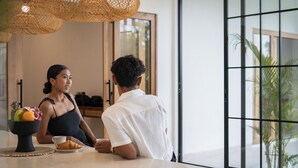 Moderni sisustus, jossa on aamiaisjärjestely: tarjolla on hedelmiä, croissant ja kahvikuppi.