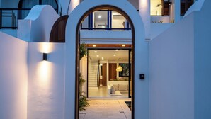 A modern house with a central archway leading to a well-lit interior. - Amal Villa By Betterplace (Canggu)