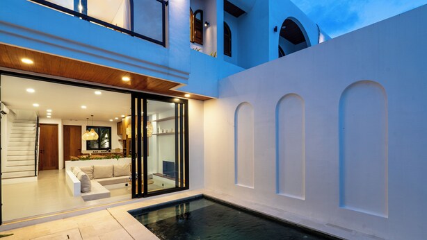 A modern house with a swimming pool, a glass door entrance, and a cozy living area with a sofa. - Amal Villa By Betterplace (Canggu)