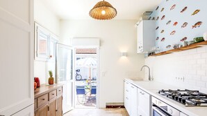 Una cocina moderna con armarios blancos, una estufa a gas y un salpicadero de azulejos.