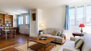 Una sala de estar con sofá, mesa de centro y estantería.