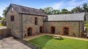 A stone building with a sloped roof and arched windows. - Broomy Barn, Bromtpon Regis (Nr Dulverton)