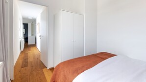 Une chambre à coucher comprenant un lit, une armoire et un couloir menant à la salle de bain.