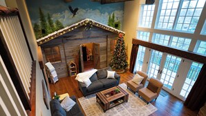 Una sala acogedora con chimenea, un árbol de Navidad y un ventanal grande.